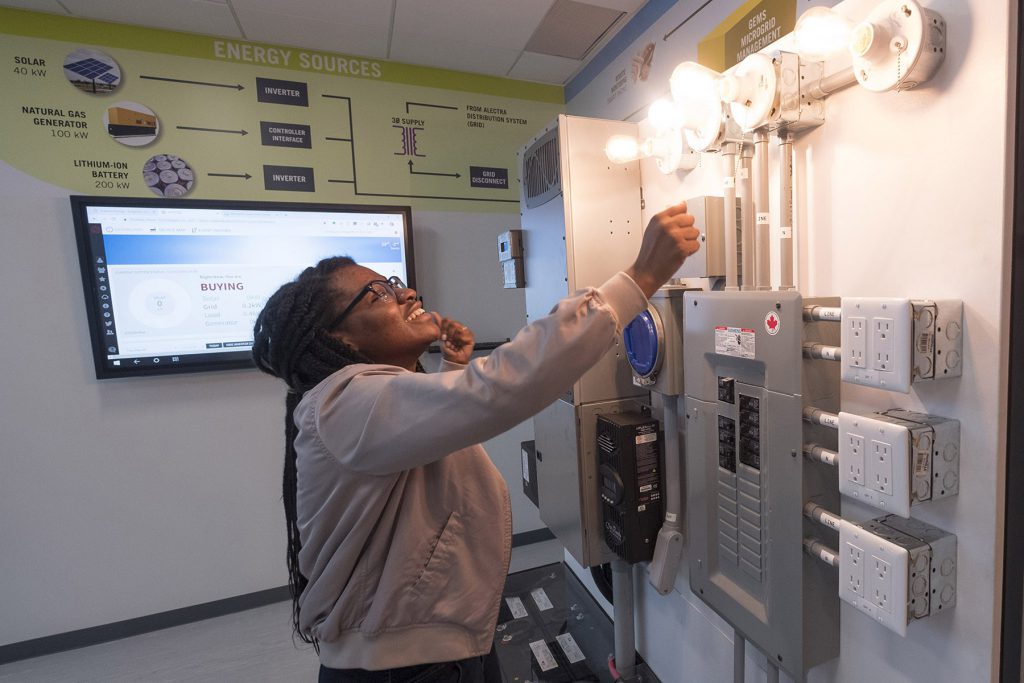 一名妇女在格鲁吉亚学院先进技术中心的电气实验室中测试控制面板。必赢彩票首页苹果官方版