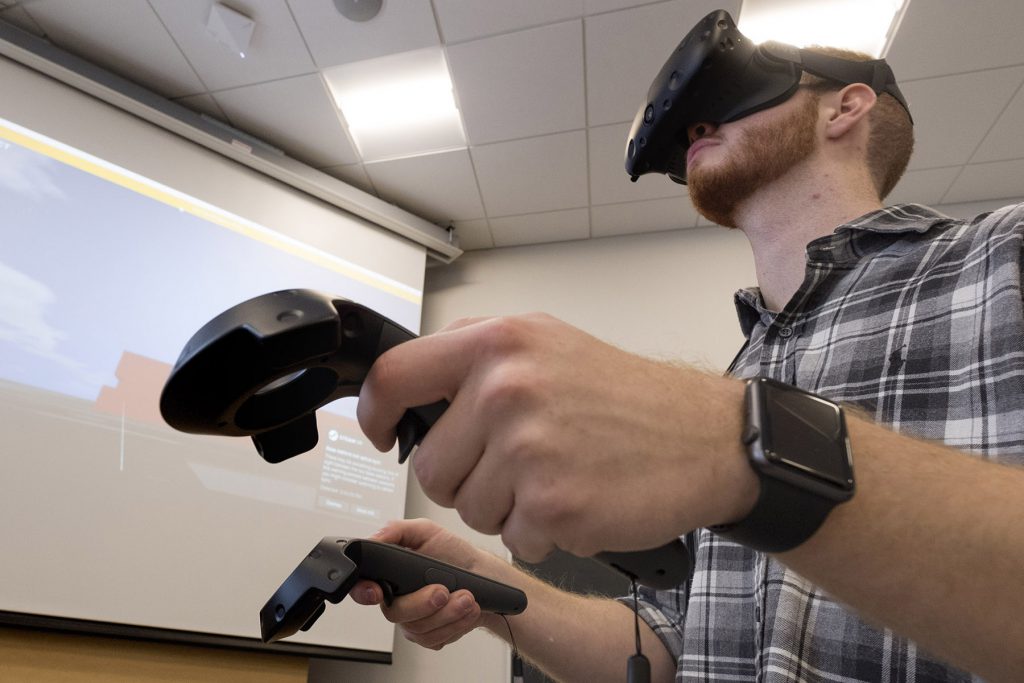一个戴着虚拟现实面具的男人，每只手都拿着一个遥控器。