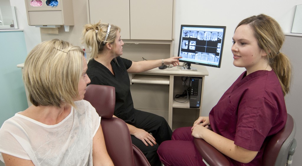 牙科学生向病人展示x光检查结果的照片