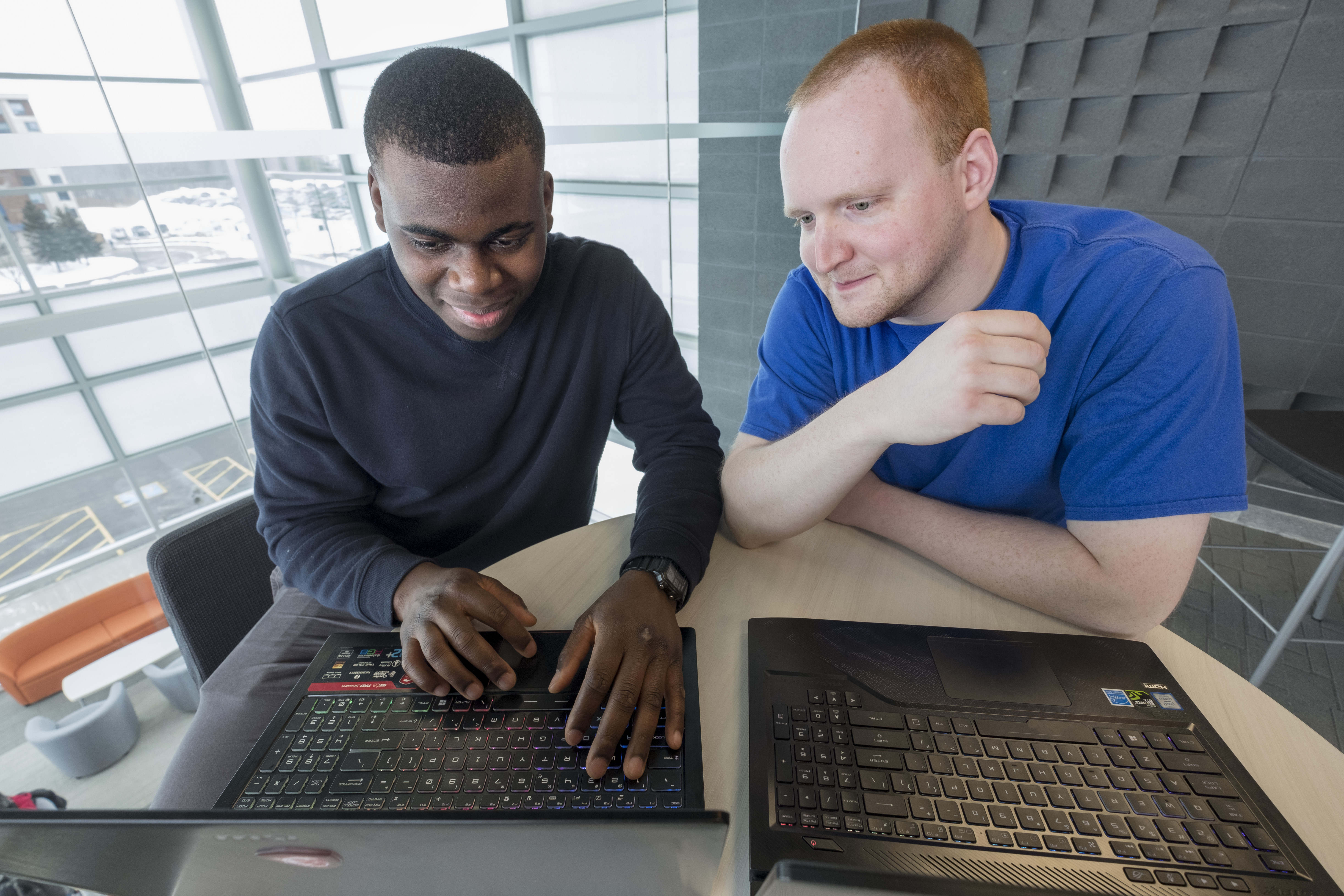 两个男学生在他们的笔记本电脑上工作