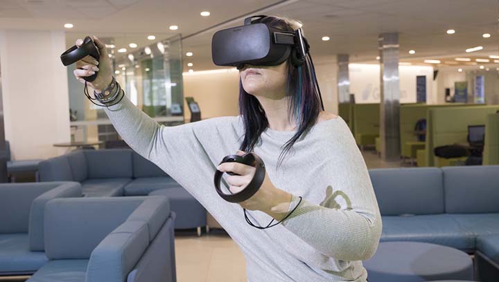 一个戴着虚拟现实头盔的女人，手握控制装置