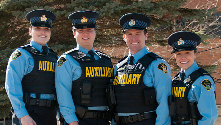 四名警察基金会的学生穿着OPP辅助队的制服站在外面
